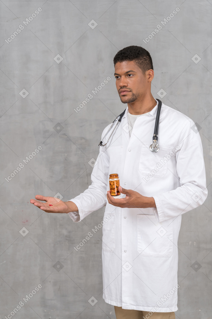 Jovem médico oferecendo uma pílula