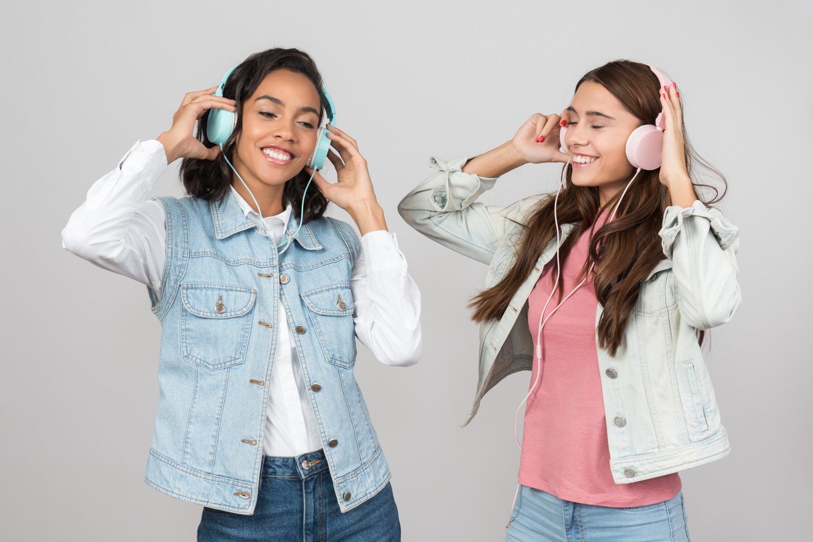 Two young women listening to music and dancing 