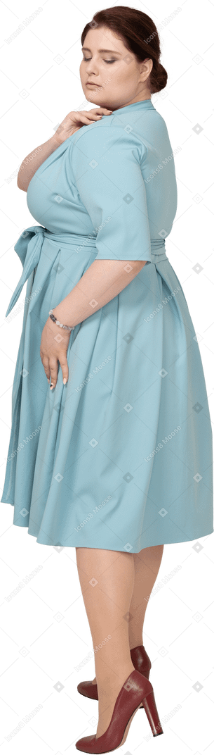 Vue latérale d'une femme en robe bleue posant