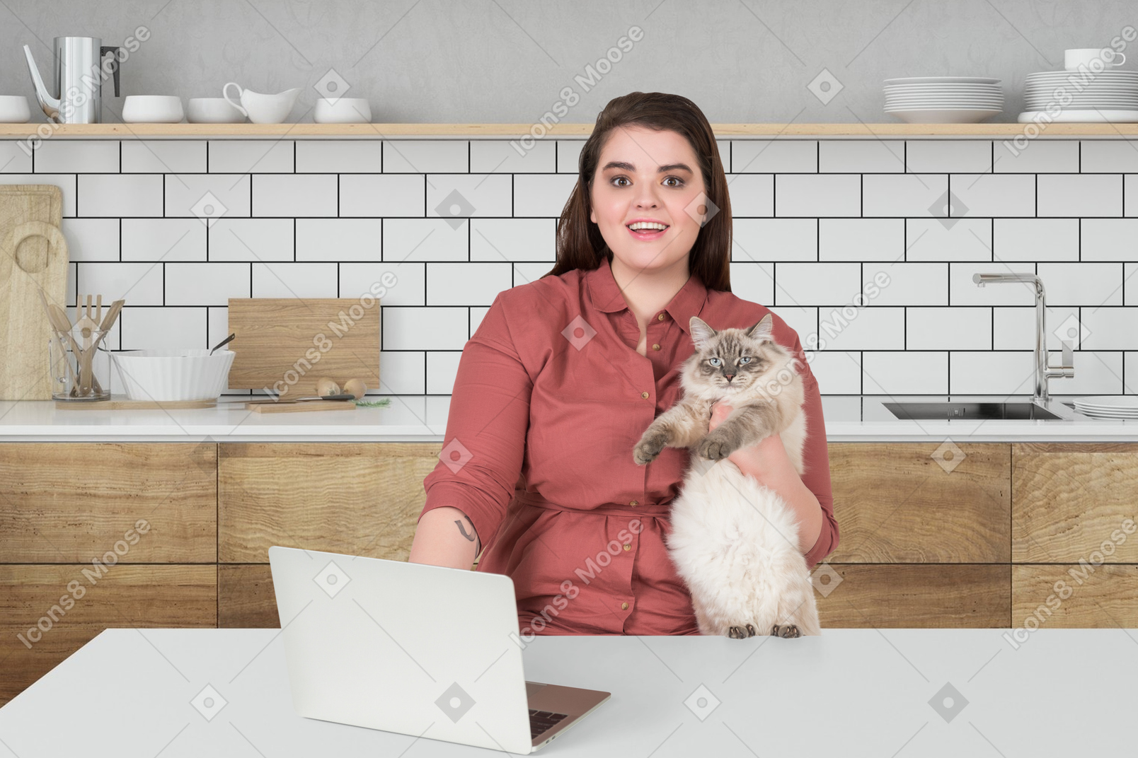 A woman sitting at a kitchen table holding a cat