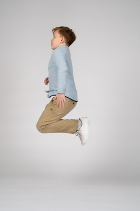 Side view of a boy jumping with bent knees