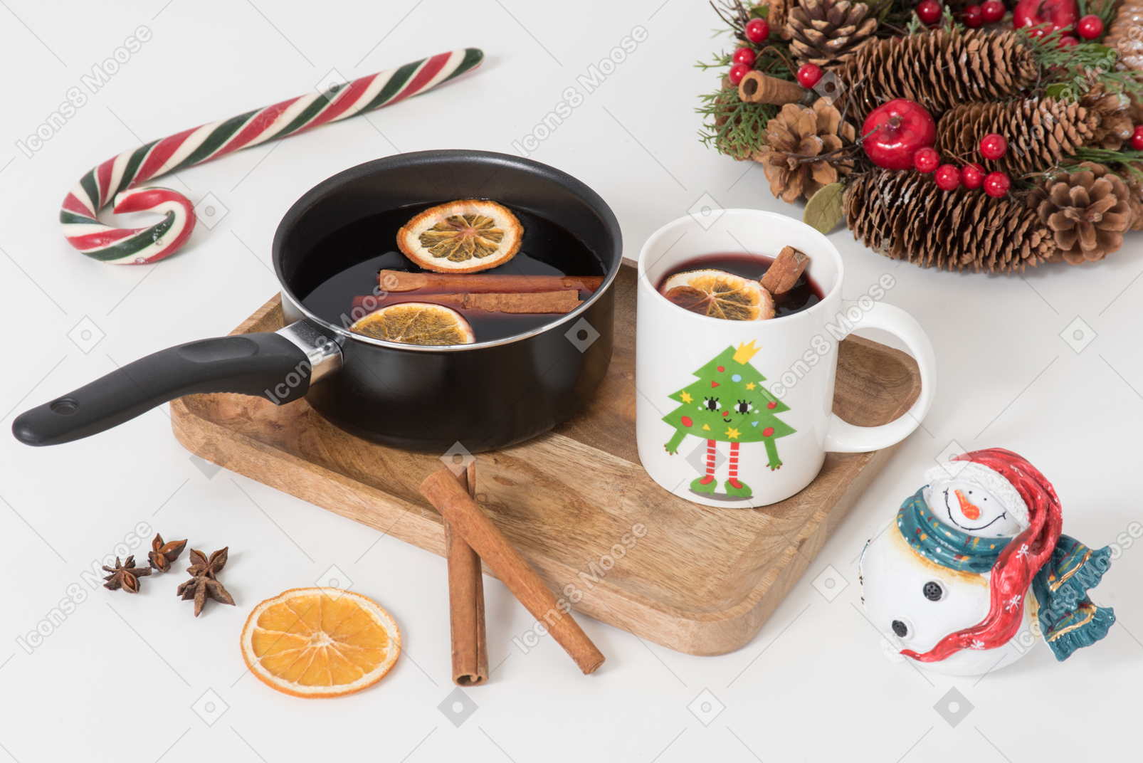 Cup and pan with mulled wine and christmas decorations near it