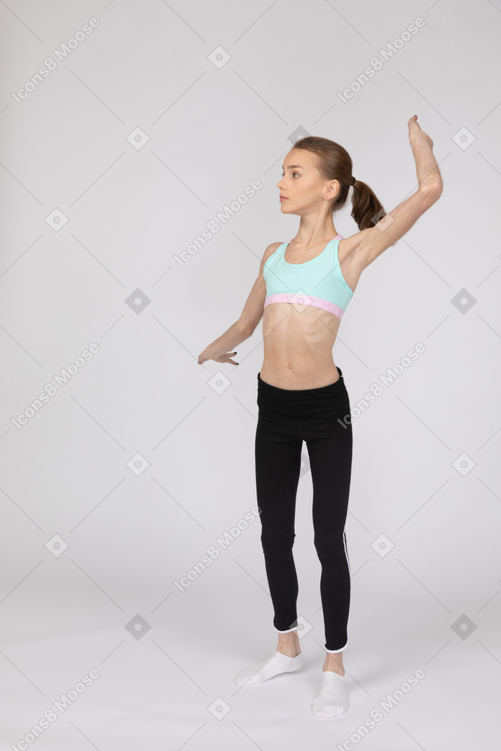 Vista frontal de uma adolescente em roupas esportivas estendendo amplamente suas mãos