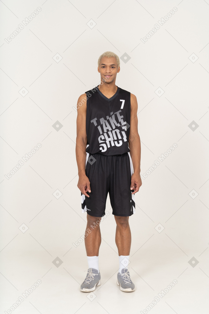 Vista frontale di un giovane giocatore di basket maschile in piedi immobile