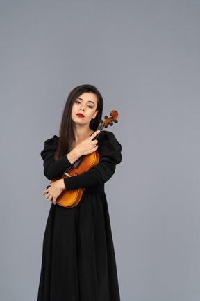 Front view of a young lady in black dress holding the violin