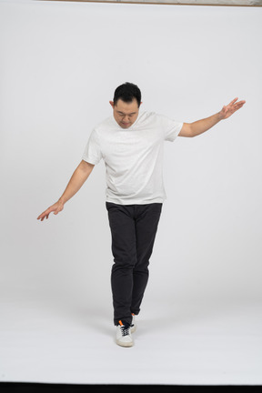 Vista frontal de un hombre con ropa informal caminando con los brazos extendidos
