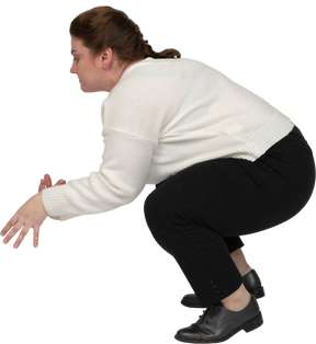 Side view of a plus size woman in casual clothes squatting