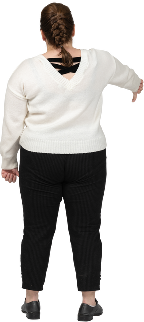 아래로 엄지를 보여주는 흰색 스웨터에 통통한 여자