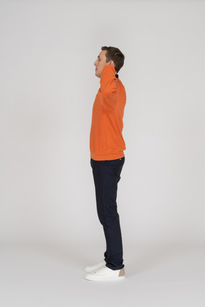 Young man in orange sweatshirt standing