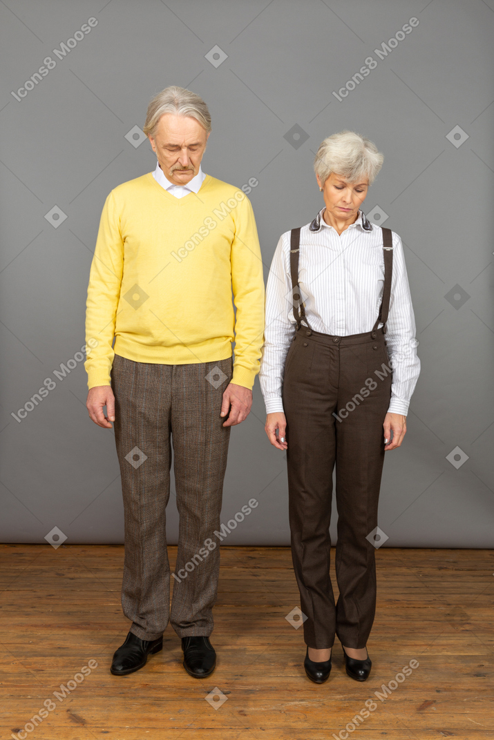Homem e mulher em pé com a cabeça baixa
