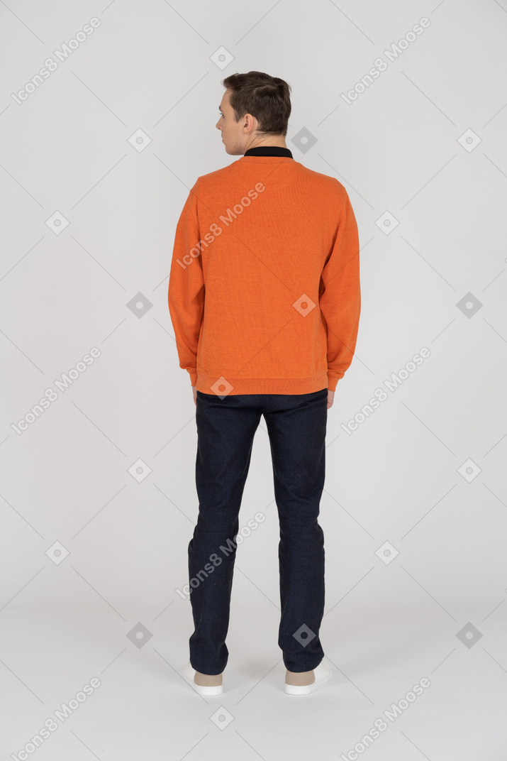 Jeune homme en sweat-shirt orange debout