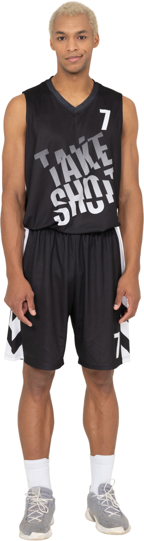 Vue de face d'un jeune joueur de basket-ball masculin souriant debout immobile