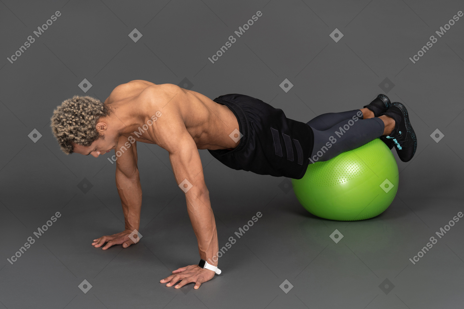 Three-quarter view of a shirtless afro man making push-ups on a gym ball