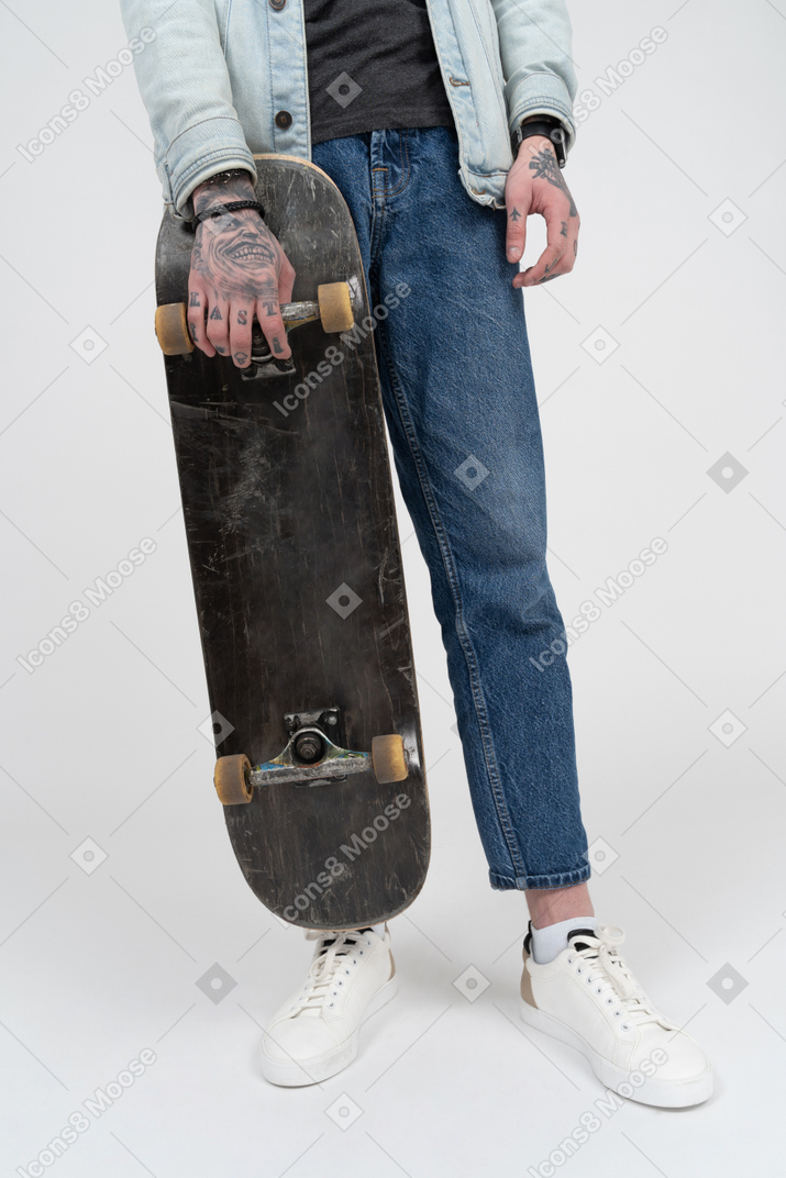 Persona irriconoscibile che tiene uno skateboard