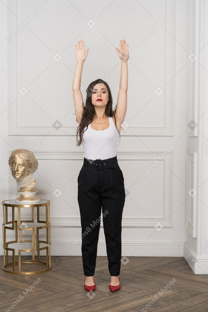 Vista frontal de la joven empresaria levantando las manos