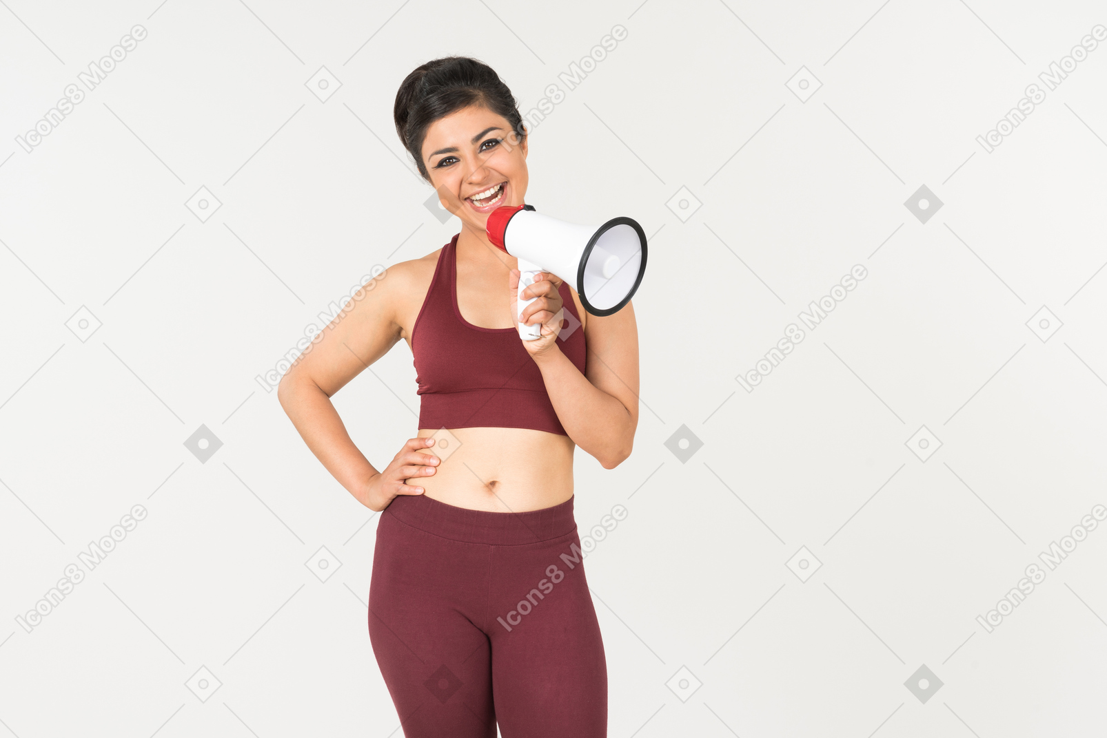 Laughing young indian woman  in sportswear holding megaphone