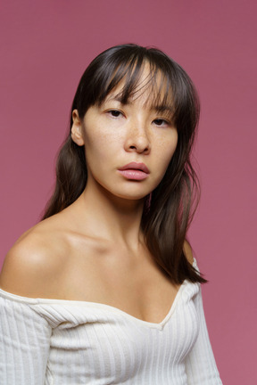 Three-quarter view of a middle-aged woman  with bare shoulder looking at camera