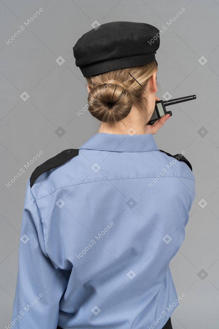 Guardia de seguridad femenina hablando por radio