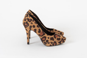 A side shot of a pair of stiletto shoes with a leopard print on