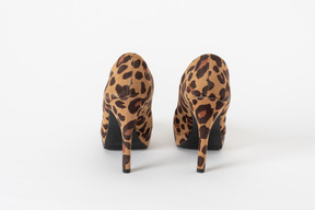 A back shot of a pair of stiletto shoes with a leopard print on