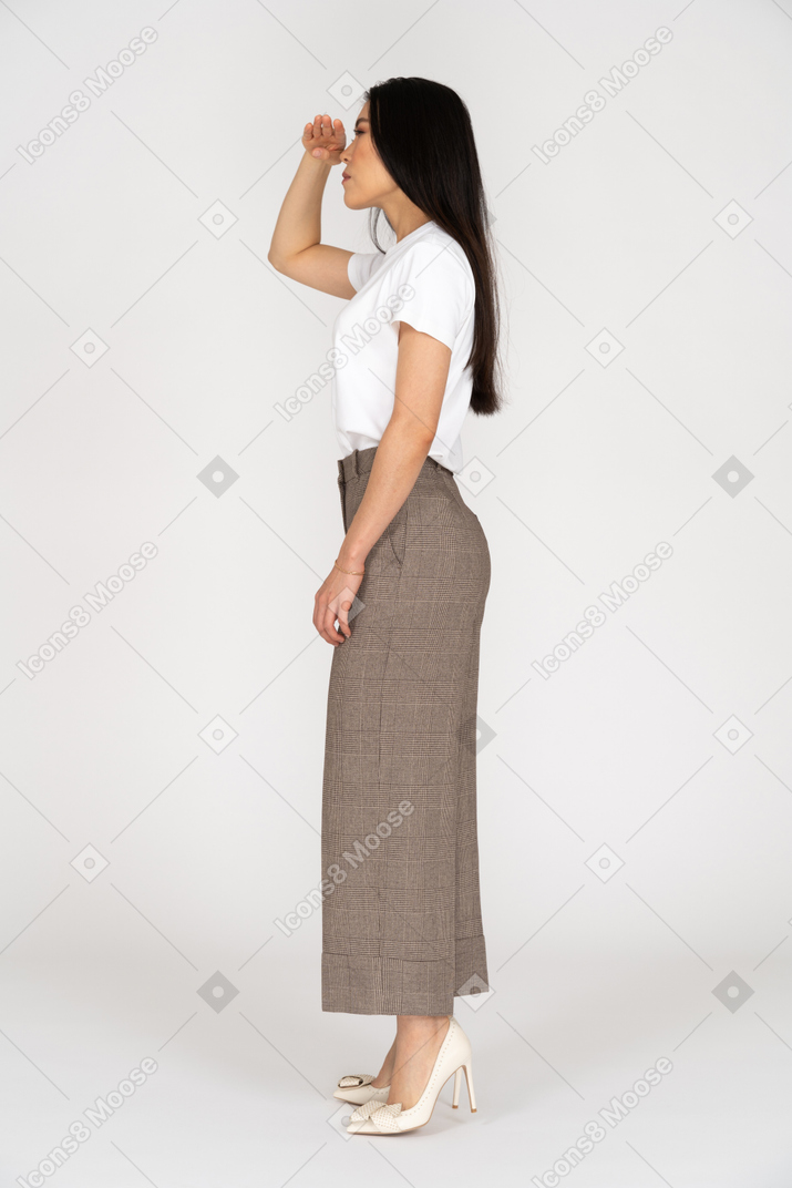 Vue latérale d'une jeune femme en culotte à la recherche de quelque chose