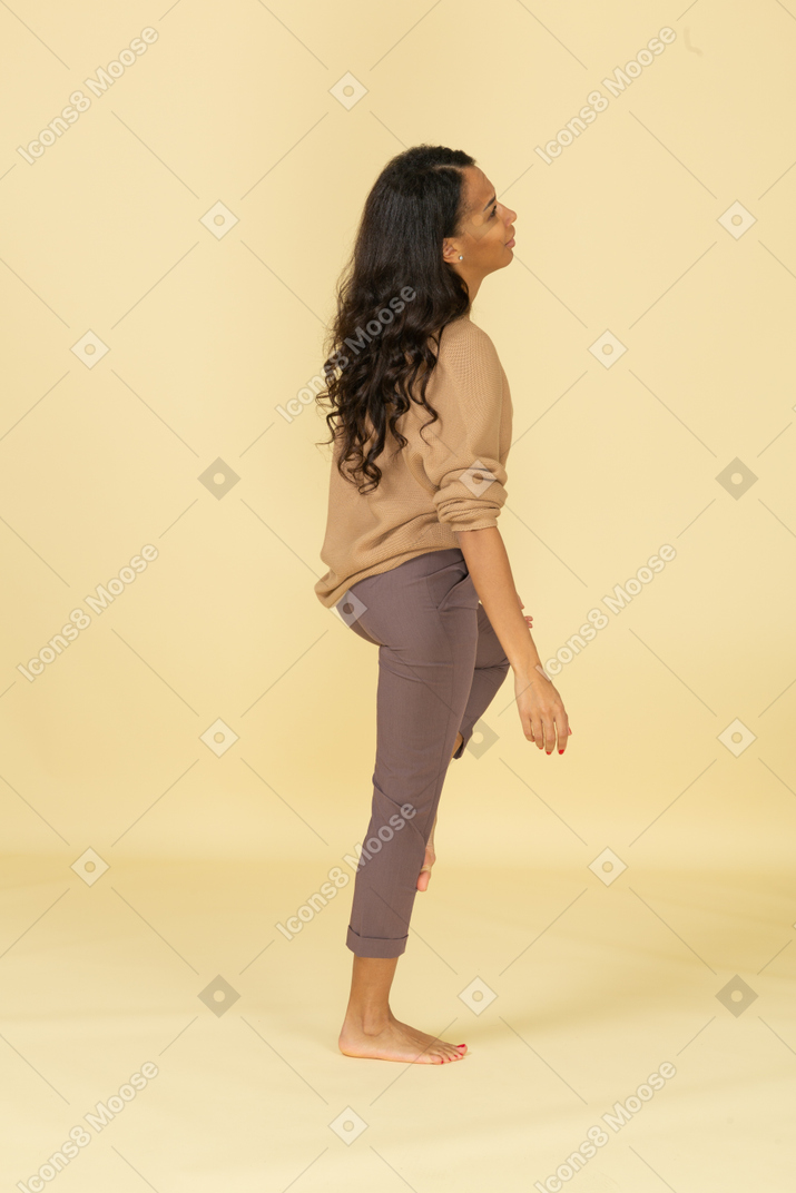 Vista lateral de una mujer joven de piel oscura cansada
