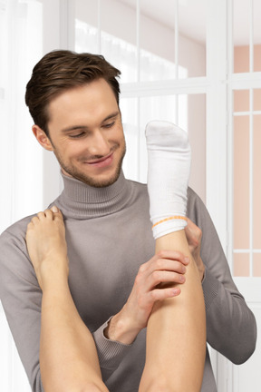 A man taking a sock off someone's leg