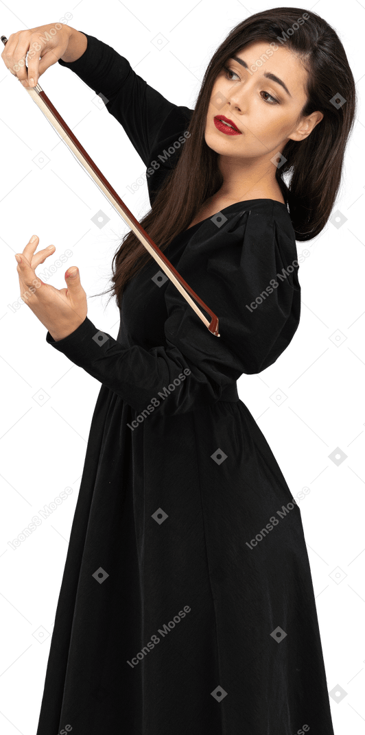 Трехчетвертный вид молодой девушки в черном платье, производящей впечатление игры на скрипке