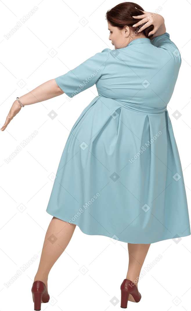 一个穿着蓝色连衣裙跳舞的女人的后视图