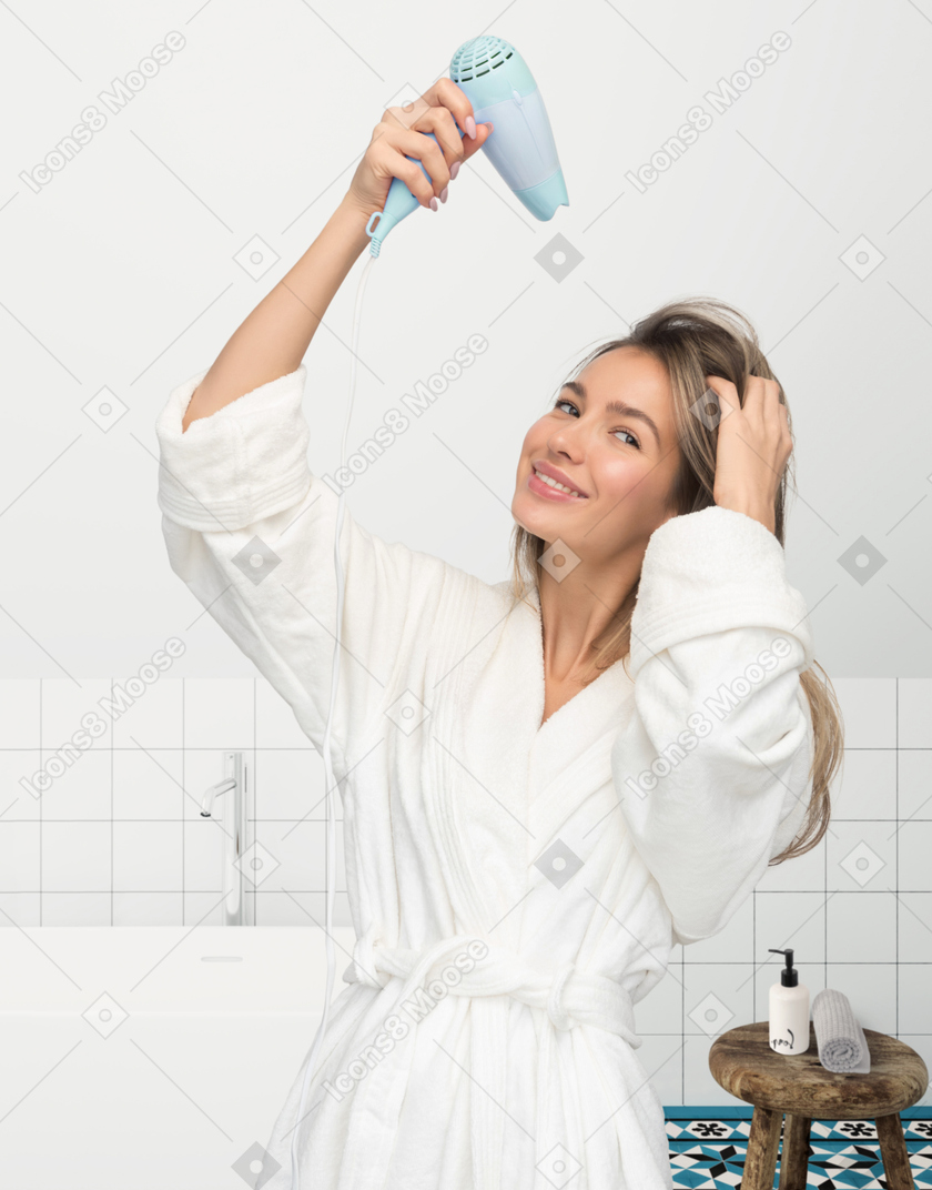 Young beautiful blonde woman using hair dryer