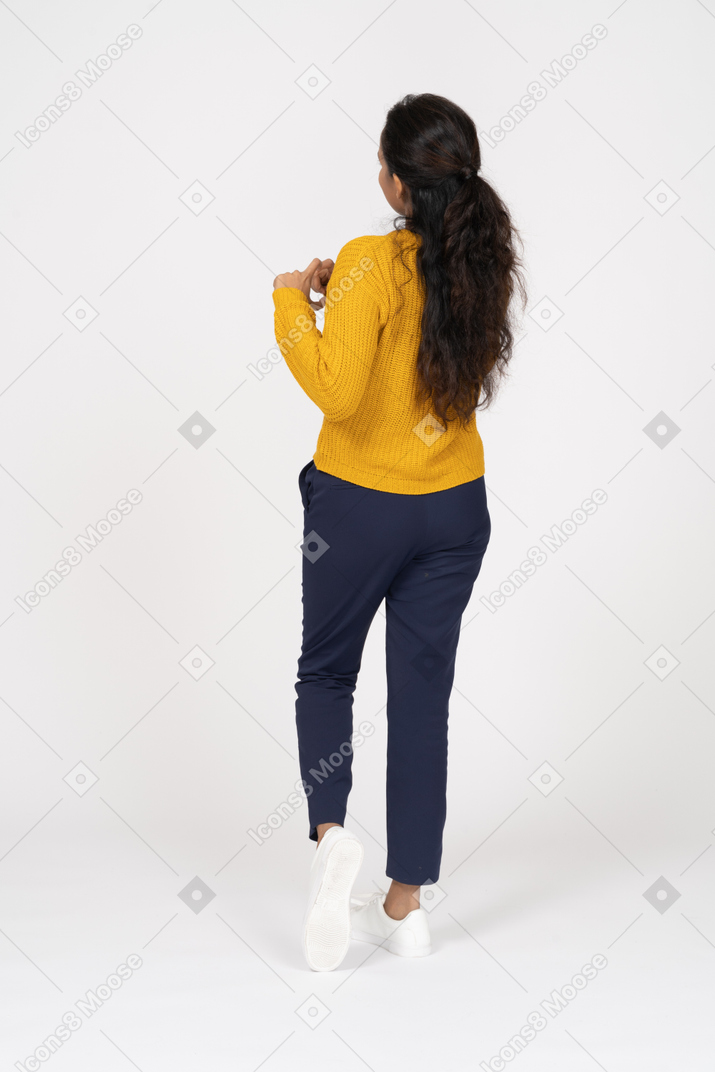 Vista posteriore di una ragazza in abiti casual che mostra il segnale acustico