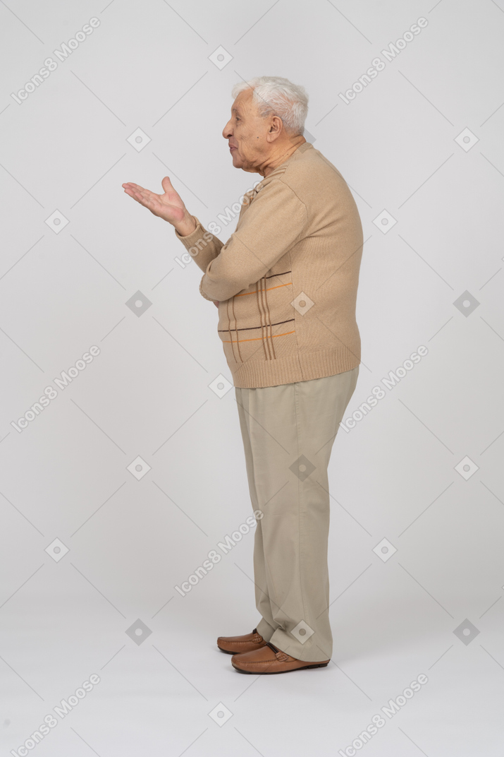 Seitenansicht eines alten mannes in freizeitkleidung, der etwas erklärt