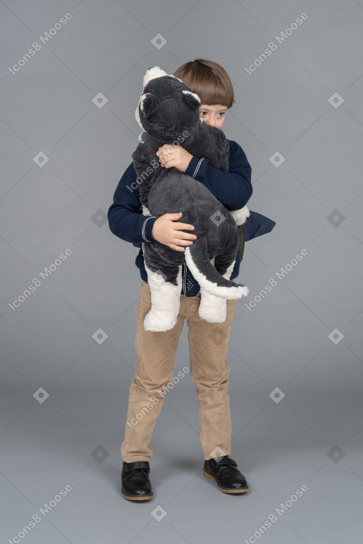 Portrait of a little boy hugging a plushie
