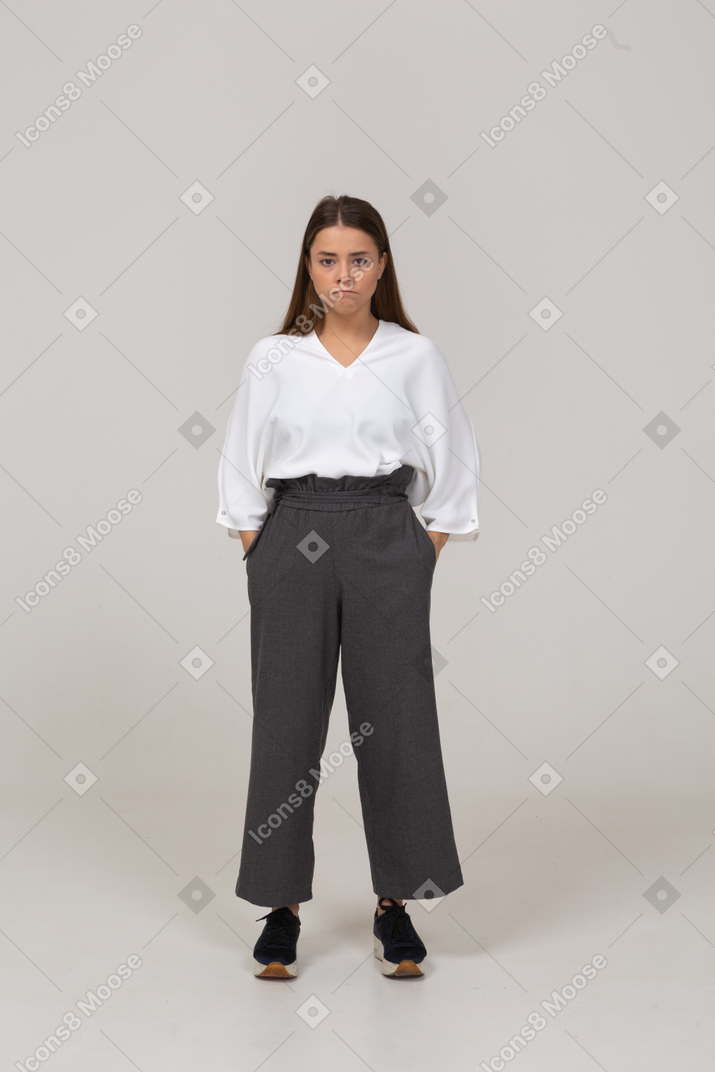 Front view of a young lady in office clothing putting hands in pockets