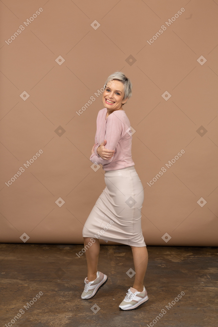 Side view of a happy woman in casual clothes looking at camera