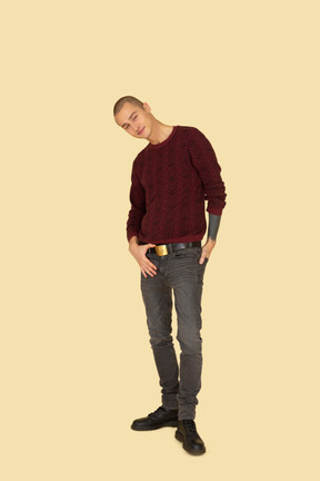 Вид спереди молодого человека в красном пуловере, касающегося его пояса