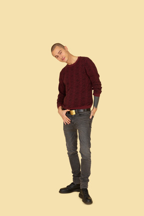 Front view of a young man in red pullover touching his belt