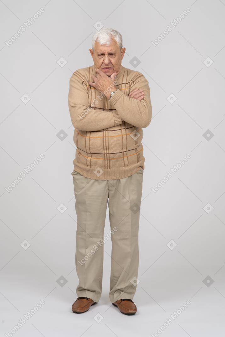 あごに手を置いて立っているカジュアルな服装で思いやりのある老人の正面図