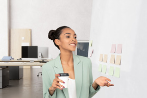 A woman holding a cup of coffee in an office