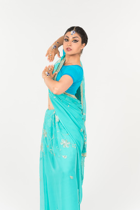 Jeune femme indienne en sari bleu debout en position de danse