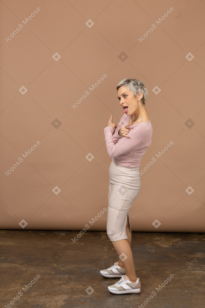 Woman in casual clothes posing in profile and making faces