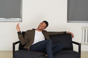 Smiling young man sitting on the sofa