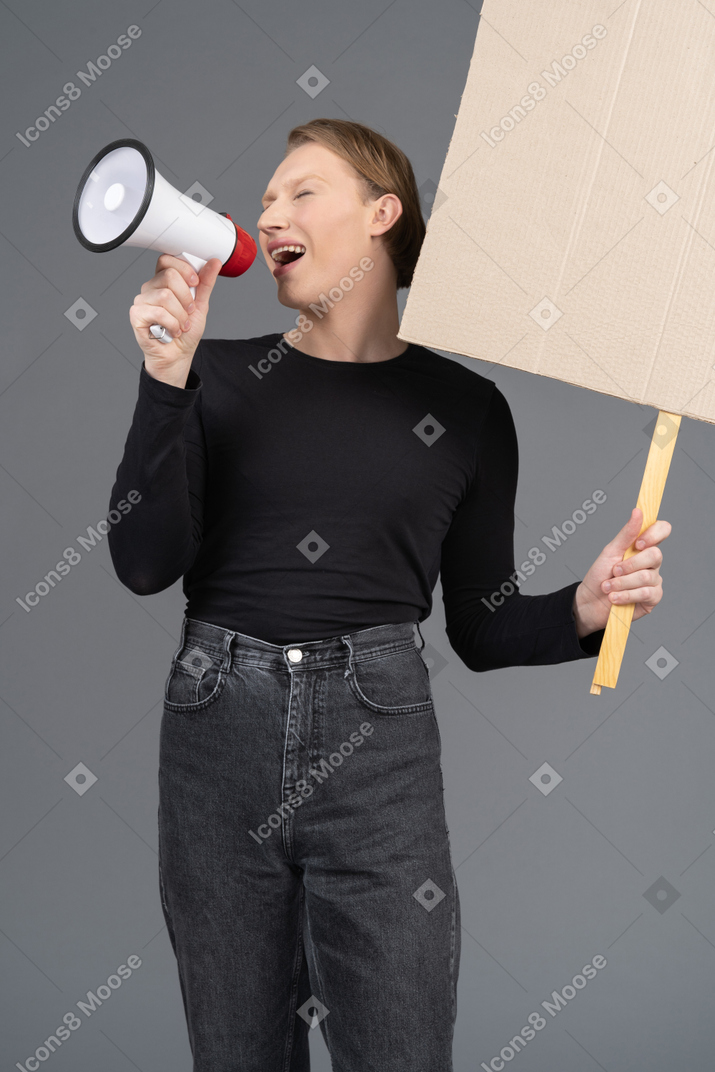 Three-quarter view of person shouting with megaphone and sign in hand