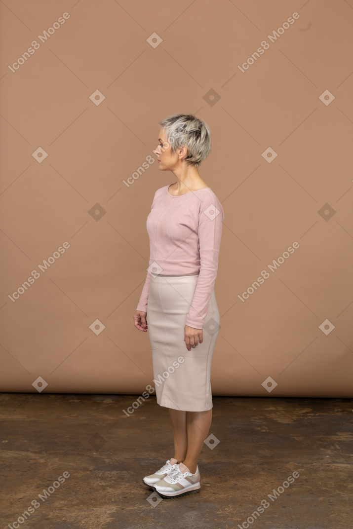 Donna in abiti casual in piedi di profilo