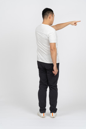 Back view of a man in casual clothes pointing at something