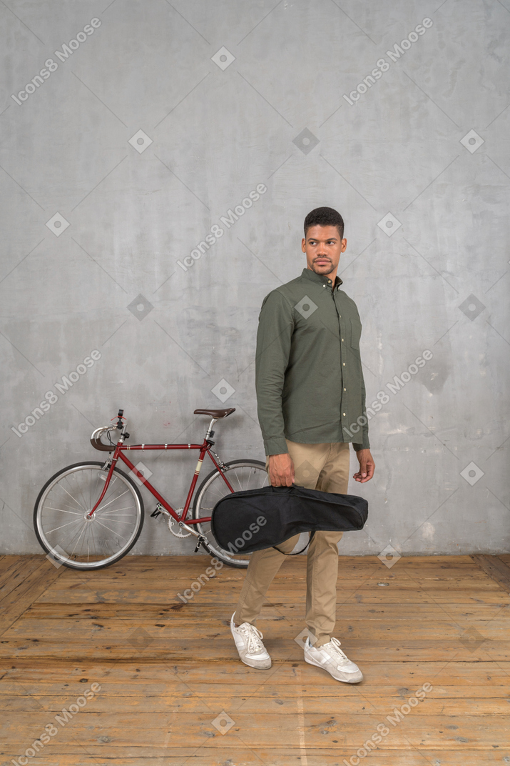 Front view of a man carrying a ukulele case