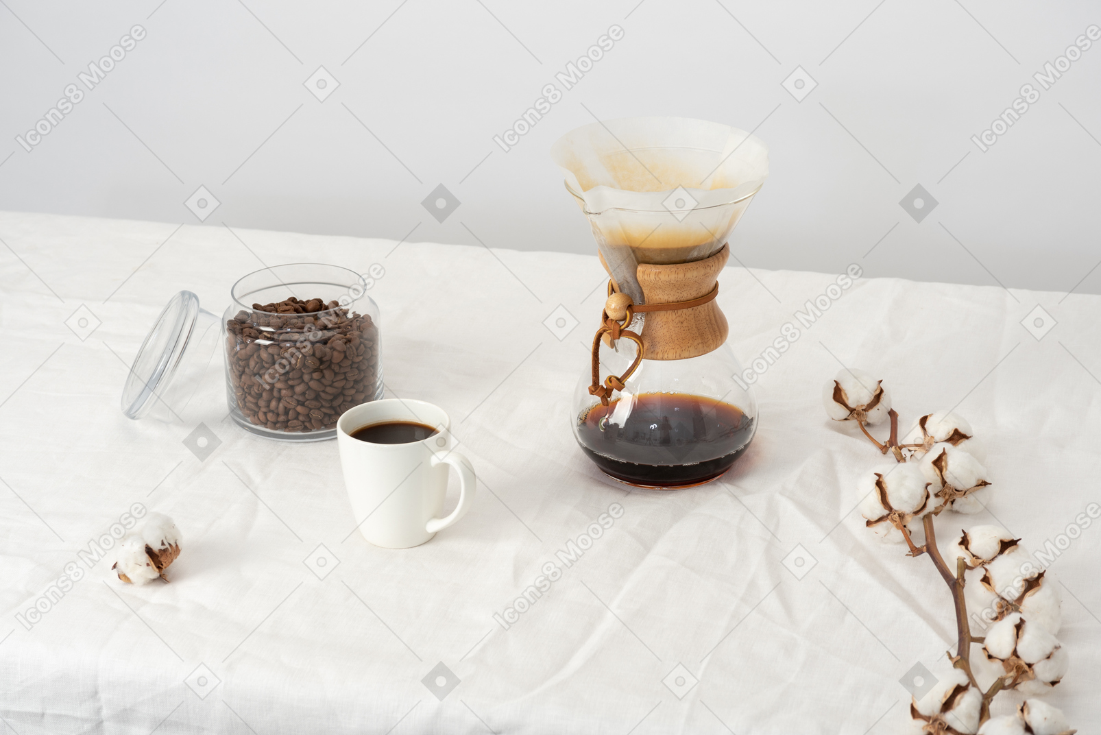 Chemex, cup of coffee, jar with coffee beans and cotton branch