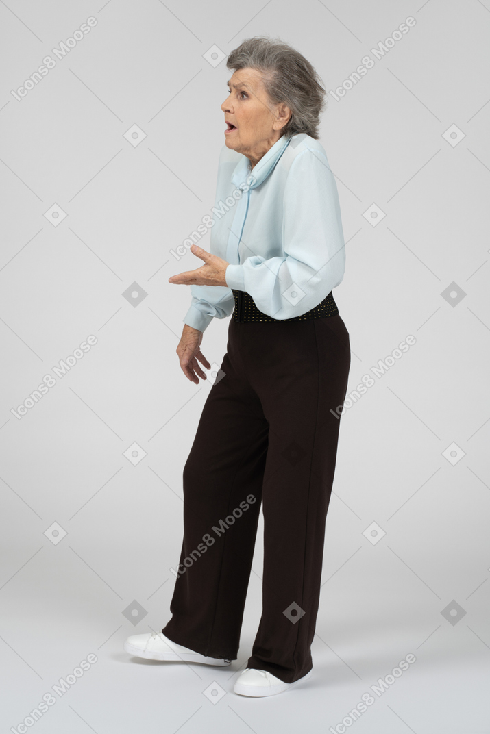 Old lady standing and making a questioning gesture