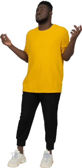 Three-quarter view of a young dark-skinned man in yellow t-shirt raising hands