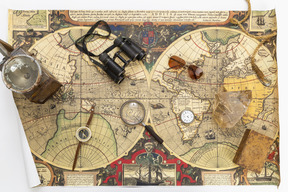Compass, vintage box, binoculars, magnifying glass on map